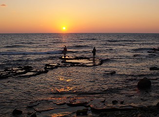 Image showing fishers in a sunset sea