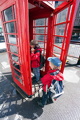 Image showing Boy talking in pay phone box