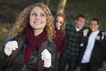 Image showing Pretty Young Teen Girl with Boys Behind Admiring Her