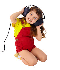 Image showing Little girl enjoys music in big headphones