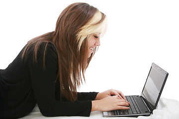 Image showing Beautiful girl relaxing on the bed with her laptop 