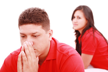 Image showing Young sad man sitting on bed, nearby unsatisfied woman. 