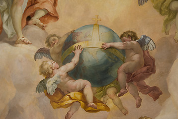 Image showing Three little angels holding the globe