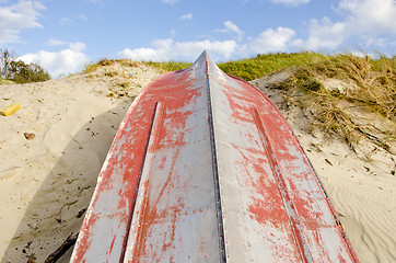 Image showing Boat made of tin upside down resting on the dunes.