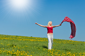 Image showing young woman with a red scarf on a meadow