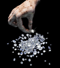 Image showing Diamonds on black surface and hand