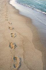 Image showing Foot imprints beside waves reaching margin. Romantic stroll.