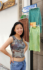 Image showing Korean woman standing next to clothes hanging up