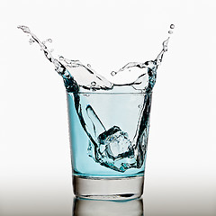 Image showing Ice cubes splashing into glass of water