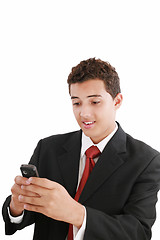 Image showing A handsome young business man texting on his phone