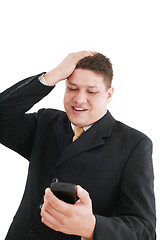 Image showing A young handsome businessman looking worried his cellphone over 