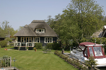 Image showing thatched cottage with a boat