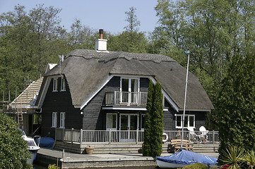 Image showing thatched cottage with a boat