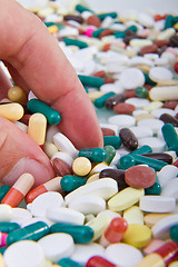 Image showing hand grabbing pills