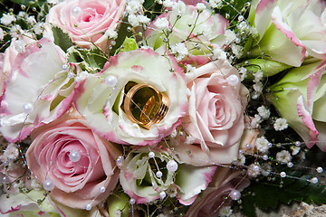 Image showing wedding rings on bouquet of bride 