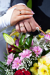 Image showing hands of bride and groon on wedding bouquet 