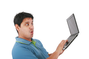 Image showing Young man standing, holding a laptop computer, working, looking 