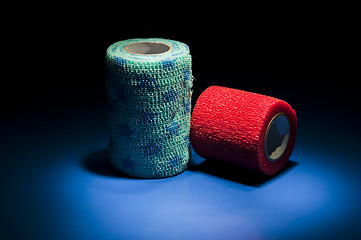 Image showing Different colour medical bandages on studio floor