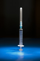Image showing Empty medical syringe standing head up