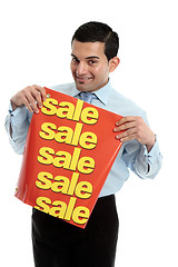 Image showing Retail salesman holding a sale sign banner