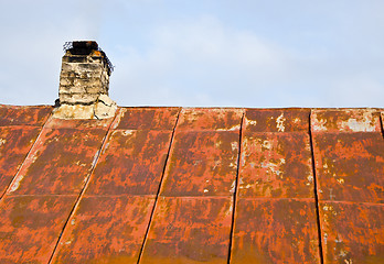 Image showing Rusty roof tin and ramshackle brick chimney.