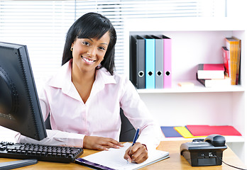 Image showing Smiling black businesswoman at desk