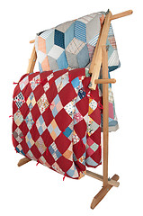 Image showing Antique Quilts On Wooden Rack.