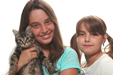 Image showing Two Sisters Holding Their Young Kitten