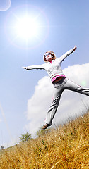 Image showing Happy woman jumping against blue sky