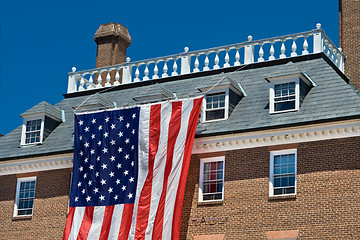 Image showing Colonial Revival Style Building with Large American Flag Blue Sk