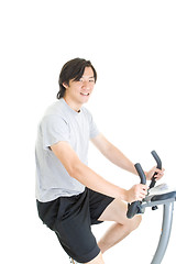 Image showing Young Asian Man Riding Exercise Bike Isolated on White Backgroun