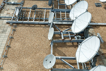 Image showing Collection of Large Satellite Dishes on Flat Gravel Roof