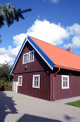 Image showing Colorful house details. Brown house with red tailed roof.