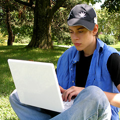 Image showing Teenager outside with a laptop