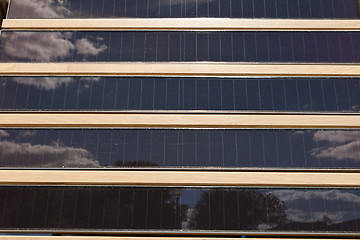 Image showing Rows of Louvered Solar Panels, Reflection Sky Trees