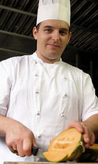 Image showing Chef is slicing a melon