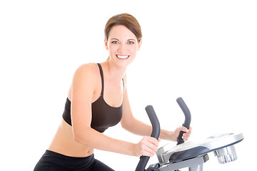 Image showing Slender Caucasian Woman Riding Exercise Bike Isolated