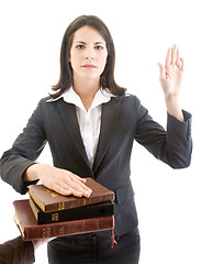 Image showing Caucasian Woman Swearing on Stack of Bibles Isolated White Backg