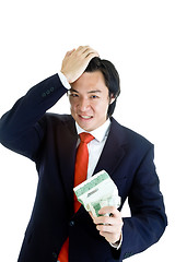 Image showing Angry Asian Man Holding Crumpled Stock Certificate Hand on Head