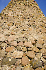 Image showing Tall wall made of many different shape stones.