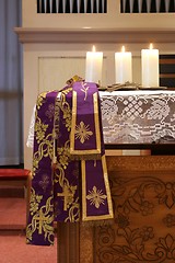 Image showing Three burning candles on church altar