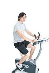 Image showing Asian Man Riding Stationary Exercise Bike Isolated