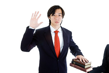 Image showing Business Man Swearing Stack of Bibles, Isolated