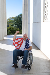 Image showing Man Wheelchair American Flag Raised Fist Blue Sky