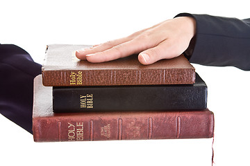 Image showing Woman's Hand Stack of Bibles Isolated Background