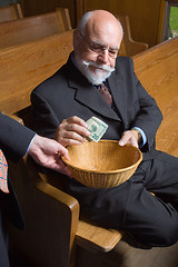 Image showing Senior Man Putting Money into Church Basket