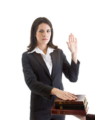 Image showing White Woman Hand Raised Swearing Stack of Bibles