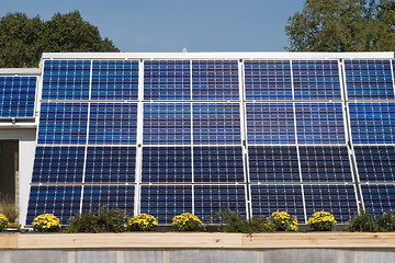 Image showing Row of Solar Panels on Roof Against Blue Sky