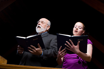 Image showing Older White Man Young Woman Singing Church Hymnals