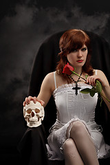 Image showing Young sexy witch with a skull and rose